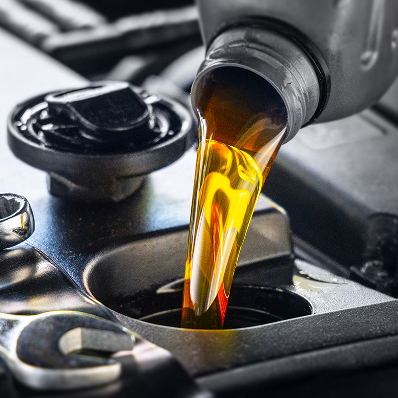 ouring motor oil for motor vehicles from a gray bottle into the engine