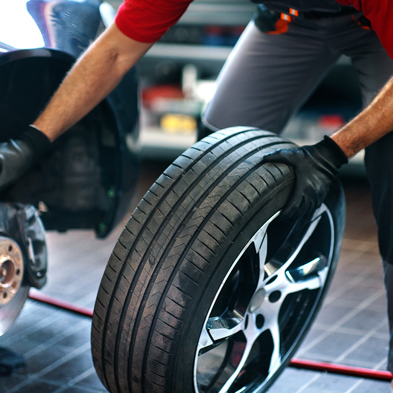 Car mechanic replacing a tire